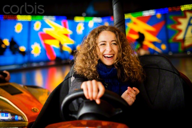 Teenage girl driving bumper car in amusement park